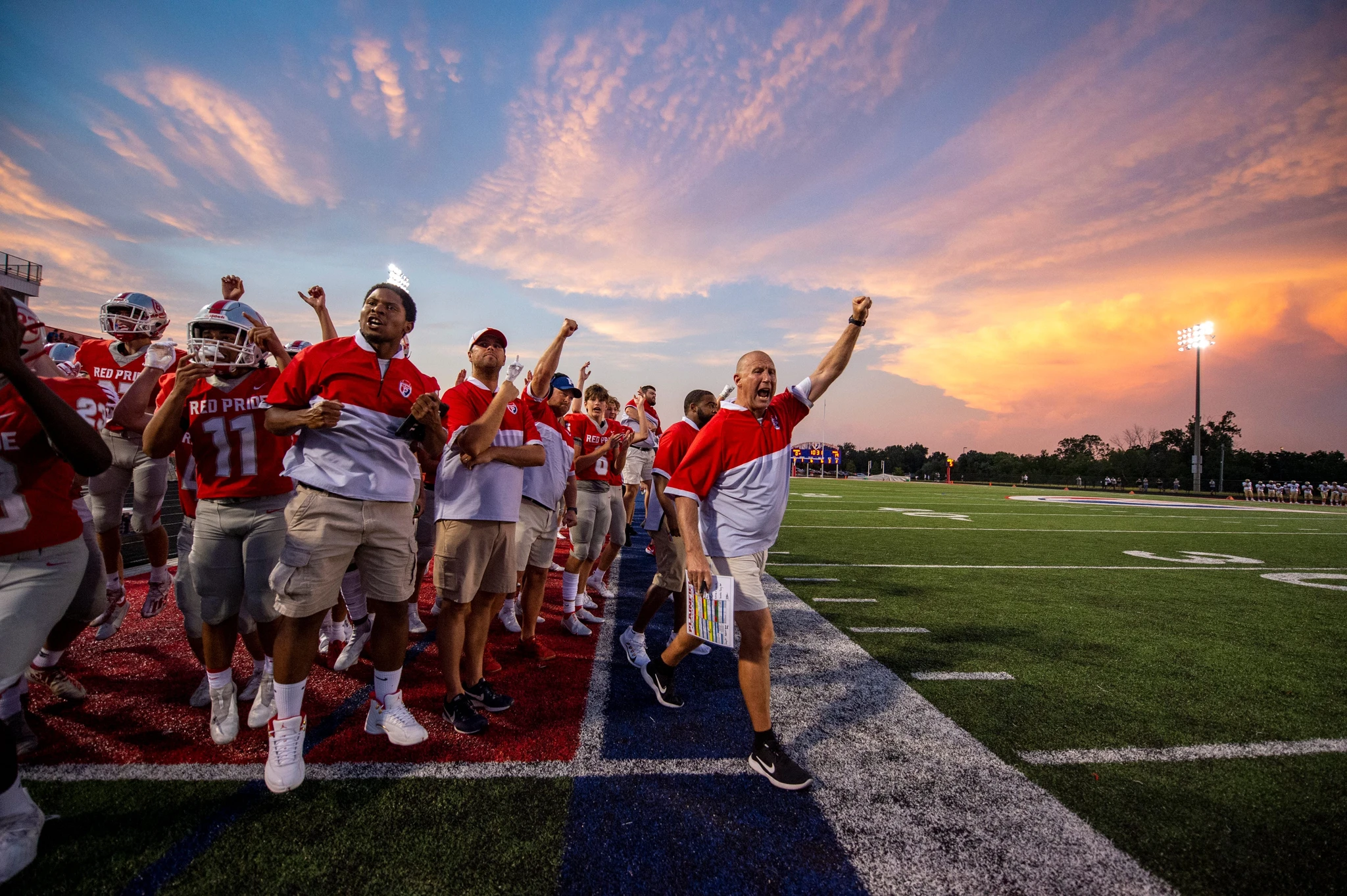 Plainfield High School offensive coordinator Derek Moyers, right, reacts with team players and coaches after a Quaker touchdown during the second half of an IHSAA college football match against Tri-West High School, the Friday August 27, 2021, at Plainfield High School. Tri-West High School won 25-20.