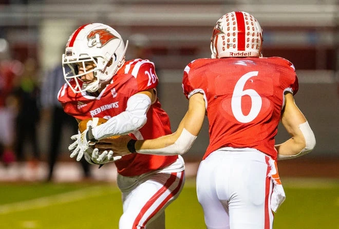 Goshen's Quinn Bechtel hands his hand to Isaiah Park during the Adams vs Goshen sectional football game on Friday, October 22, 2021 at Goshen High School.