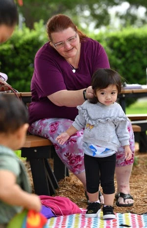 Erica Pramudyasworo puts her daughter, Isabella's hair in a ponytail during the Musical Motion program.